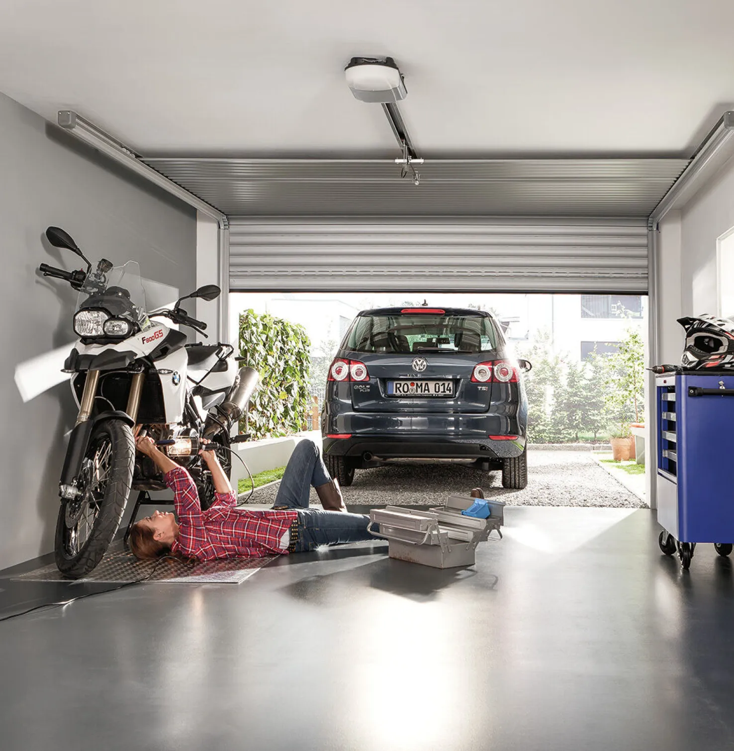 Vrouw ligt op motor in garage, auto voor haar