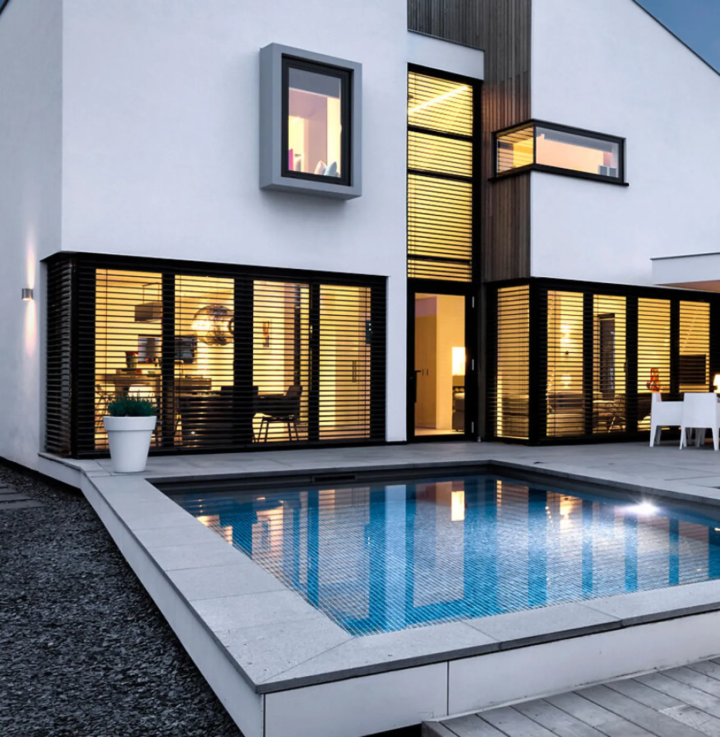 Huis met zwembad en Buitenjaloezieën van binnen helder verlicht